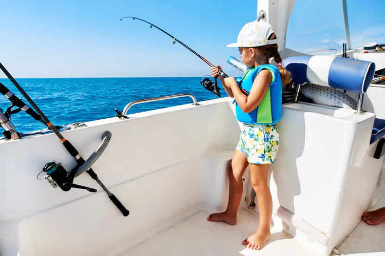 young girl fishing from boat