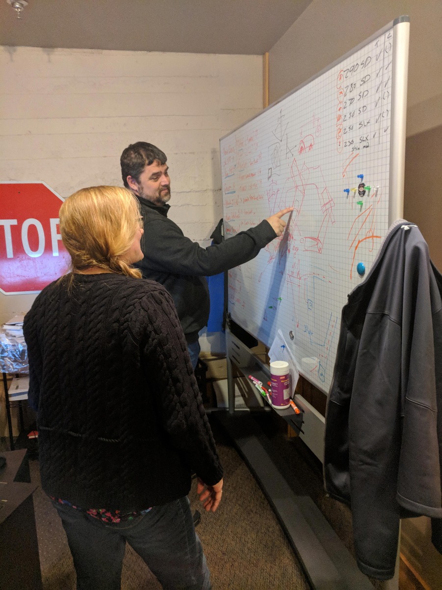 man and woman working at whiteboard