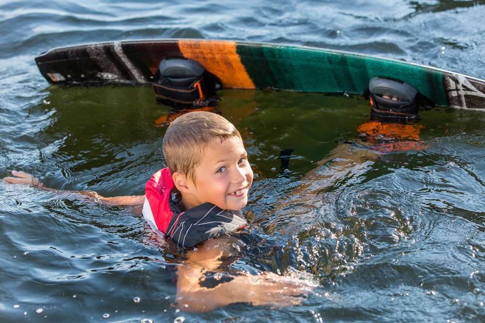 boy with wakeboard in water