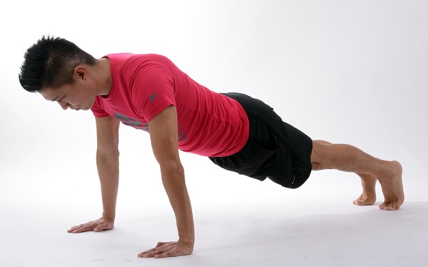 man performs plank exercise