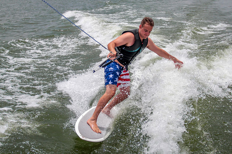 man wakesurfing behind a boat