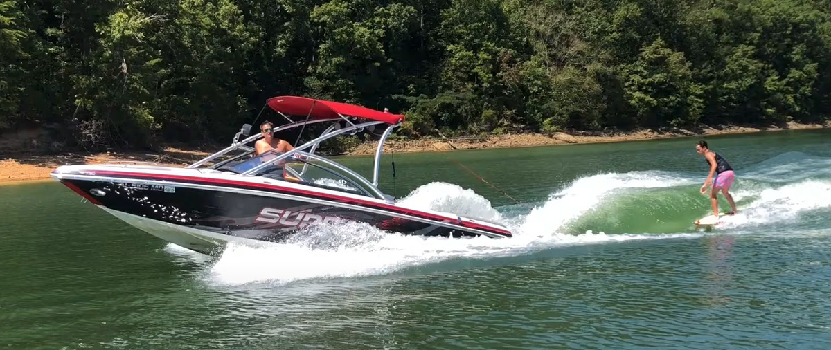 man wakesurfing behind supra boat with surfmode wake shaper